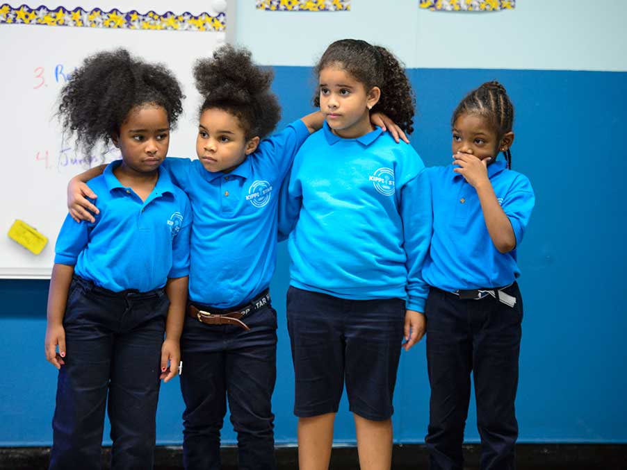 four young girls in blue t shirts