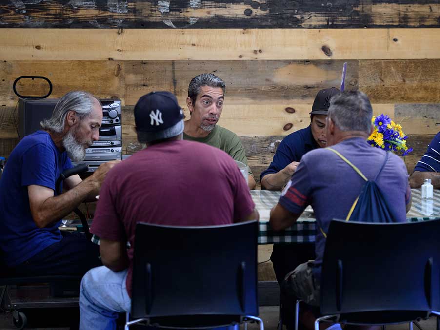 men sitting at a dinner table eating