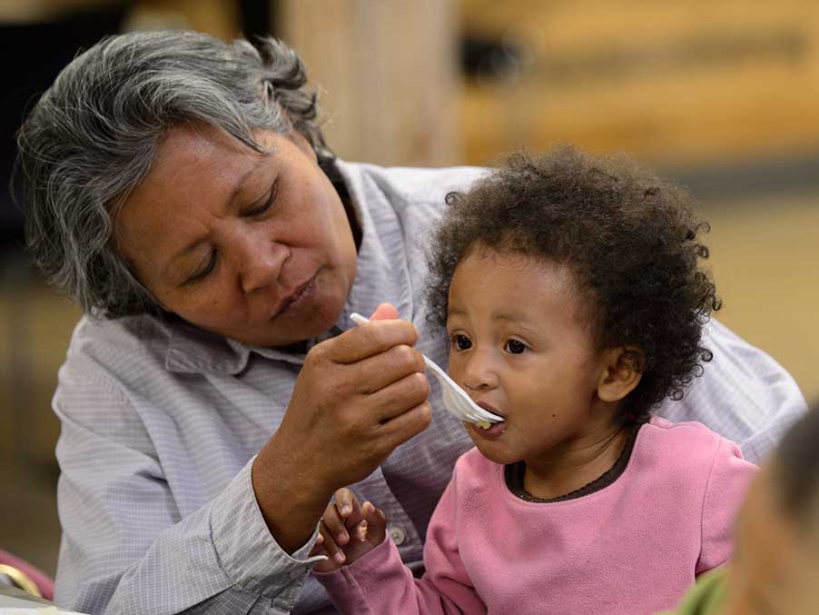 a mother spoon feeding her child