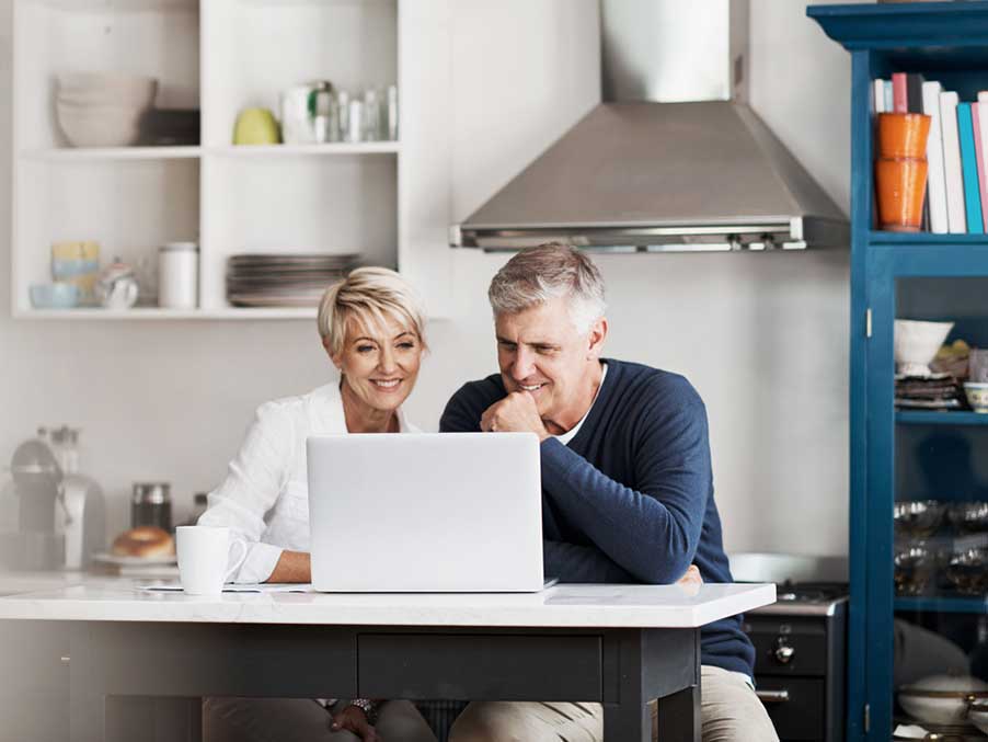 a couple on a laptop in their kitchen